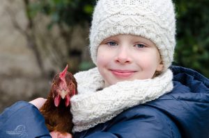 Kinderfotografie in der Schweiz Kind und Huhn im Portrait